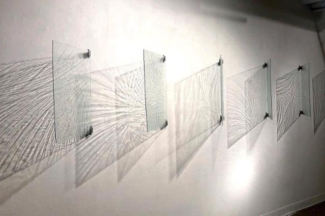 Six glass panels on wall, casting rippled shadows.