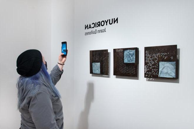 person taking a picture of artwork on their phone