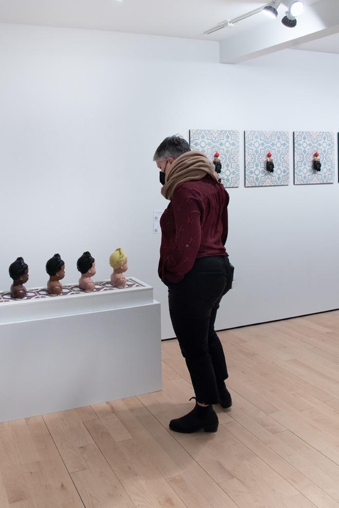 person looking at series of black vases