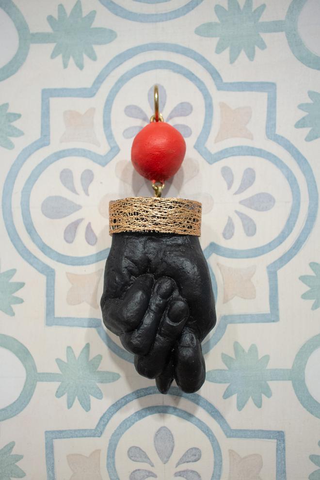 detailed view of a red ball linked to a black hand