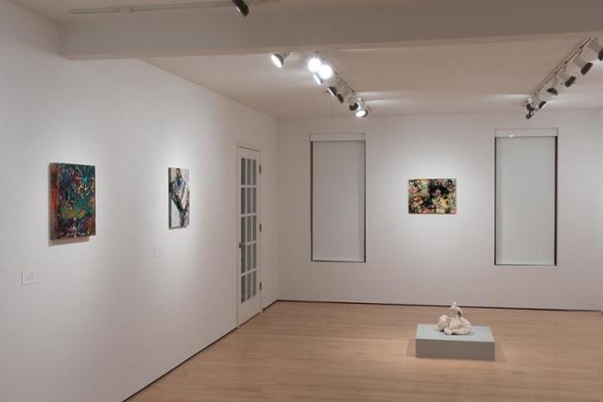 another corner of gallery space featuring various sculptures and paintings