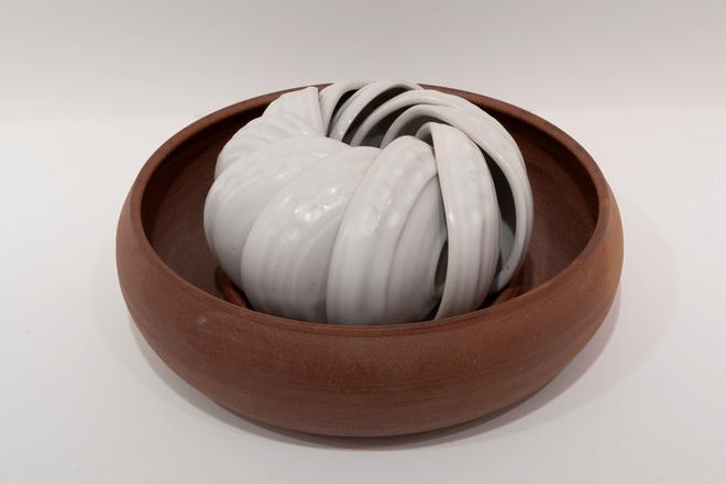 white bowls creatively nested in a bronze larger bowl
