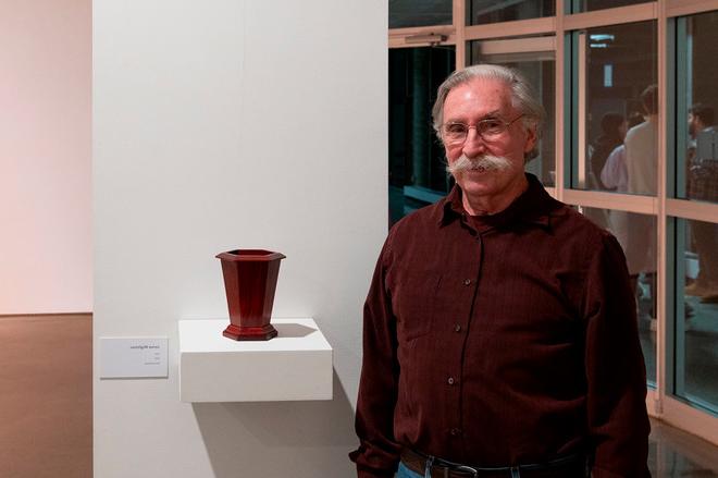 artist Jim posing next to a vase of theirs