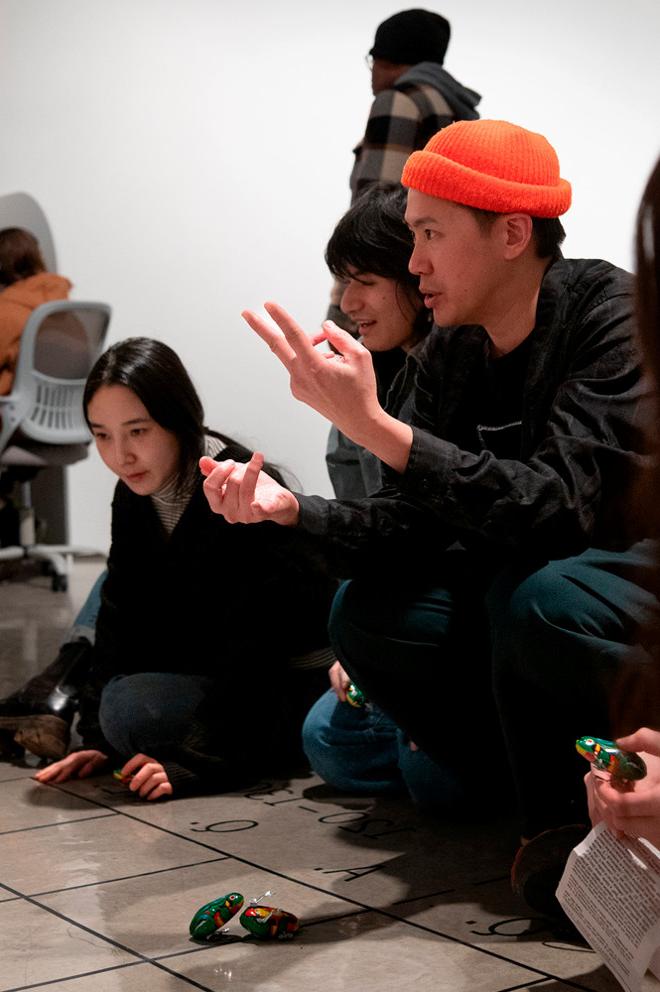 artist talking to people playing with toy cars