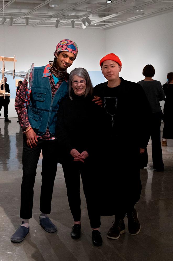 gallery director and artists posing with artwork